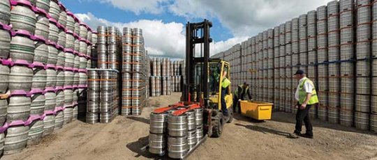 Men loading a fork lift with barrels